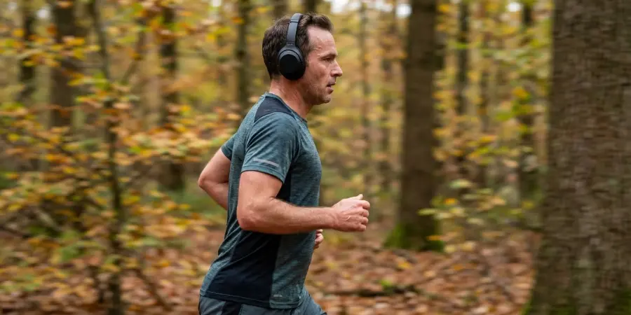 En man är ute i en höstskog och springer medan han lyssnar på musik