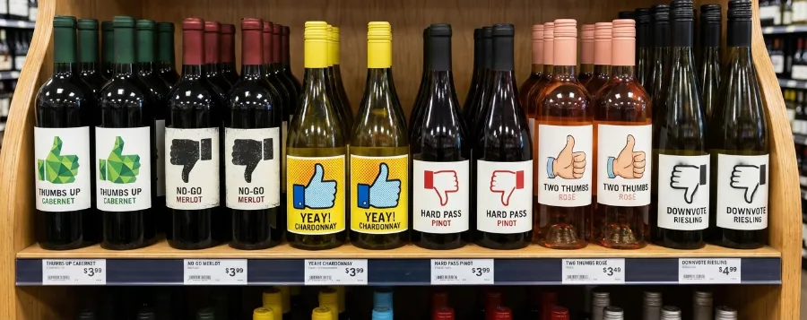 En vinhylla med sex olika flaskor där etiketterna har tumme upp och tumme ner. Själv står jag och väljer mellan Yeay! Chardonnay (som förvisso är vitt) eller No-Go Merlot.