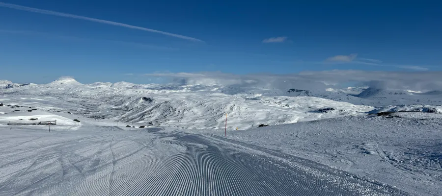Något av det vackraste man kan se. En nypistad backe, en blå himmel flankerad av en spektakulär bergskedja.