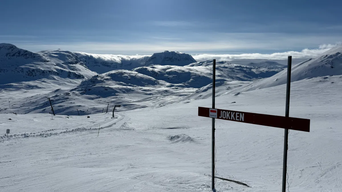 Utsikt över nedfarten Jokken, vit snö, blå himmel, strålande sol, snöiga berg. Det är vackert, oerhört vackert.