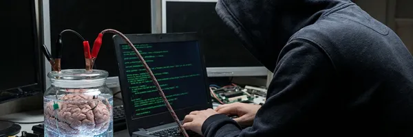 En hacker sitter med sin laptop och programmerar om en hjärna. Det kan du också göra